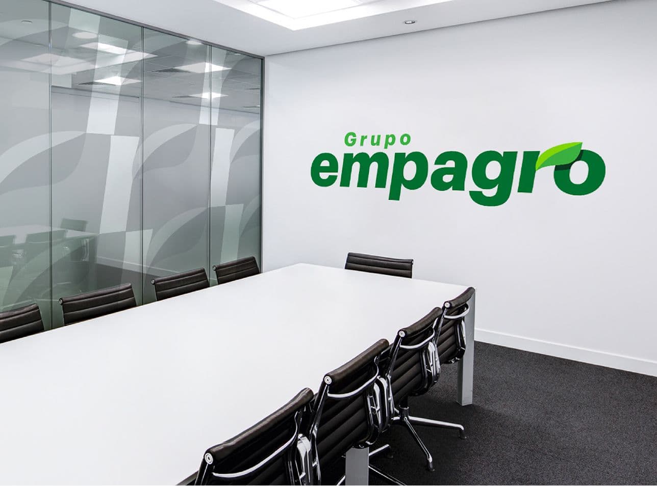 Meeting room with the Grupo Empagro logo on the wall and leaf graphics on glass.